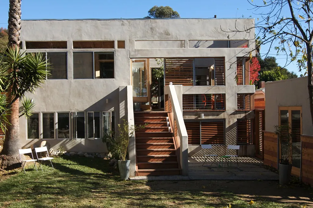 The front of a modern Los Angeles house with wood stairs and a small courtyard.
